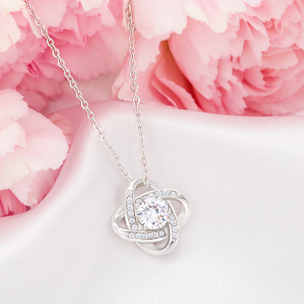 14K White Gold Finish Love Knot Necklace on display in front of pink roses for mom